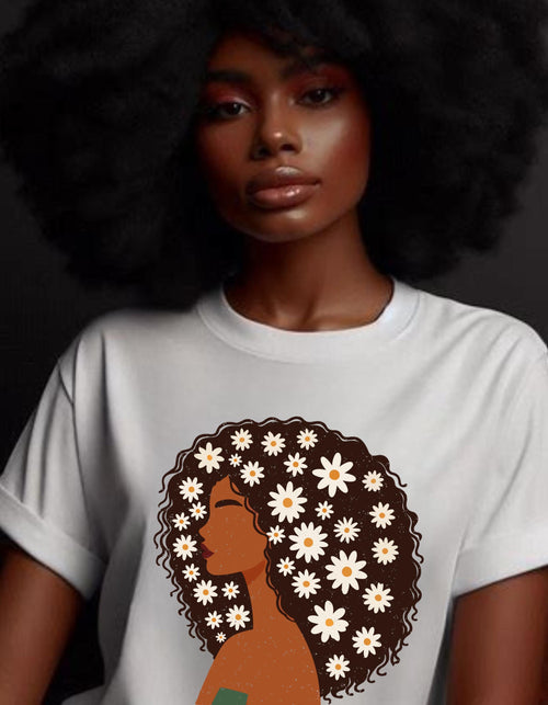 May include: A white t-shirt with a brown and white illustration of a woman with curly hair decorated with white flowers.